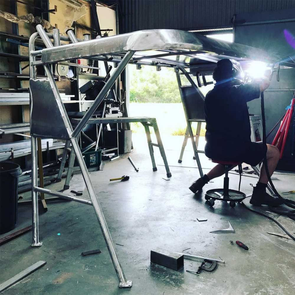 Nicholas Hughes welding marine boat roof in the shed at Nicholas Hughes Engineering Ballina